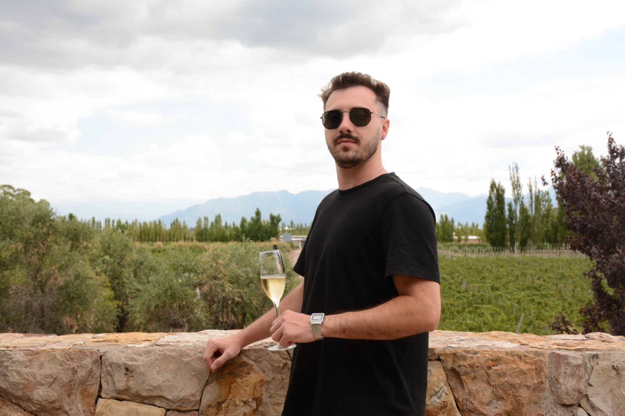 Freddy en un viñedo con una copa de vino